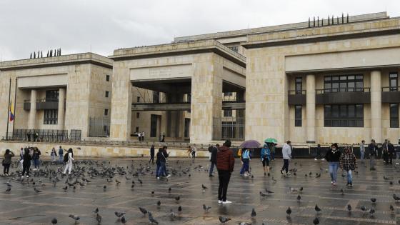 Personas caminan frente al Palacio de Justicia este jueves en Bogotá (Colombia).