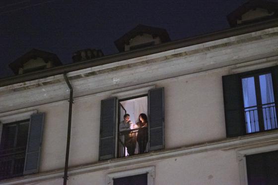 Una pareja en un balcón se suma a otras personas de todo el país para encender una vela por la gente enferma, en Milán, Italia, el 15 de marzo de 2020. (Alessandro Grassani/The New York Times)