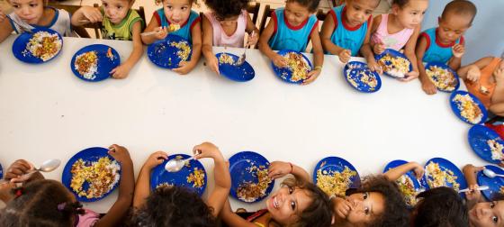 FAO/Ubirajara Machado Niños comiendo en su colegio dentro de un programa escolar en América Latina.
