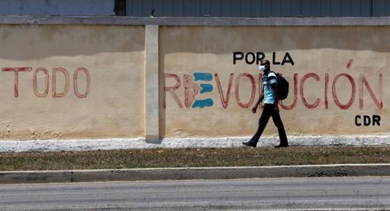Un hombre camina hoy frente a un mural en apoyo a la revolución, días antes del VIII Congreso del Partido Comunista de Cuba (PCC)