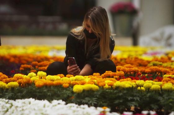 Mujer Posa junto a el Tapiz de flores 