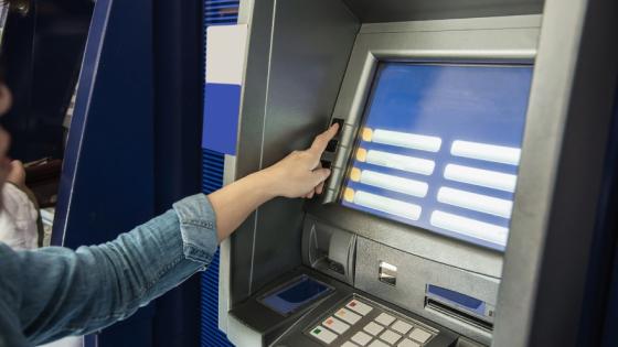 Persona sacando plata de cajero.