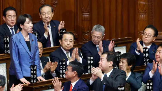 Sanae Takaichi, de traje azul, se pone de pie en el Parlamento japonés mientras varios legisladores la aplauden tras ser elegida como la primera mujer en ocupar el cargo de primera ministra de Japón.