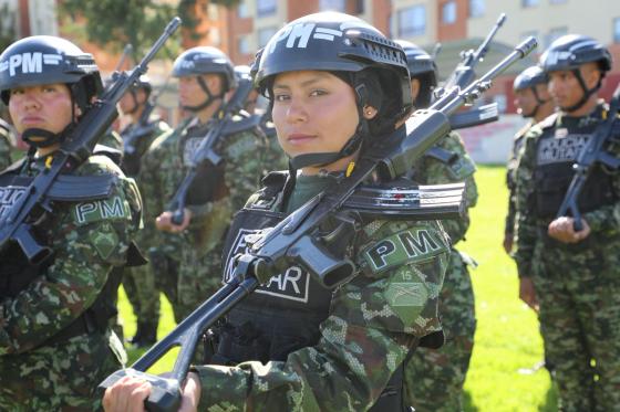 Oficial del Ejército en formación militar, acompañada de otros soldados