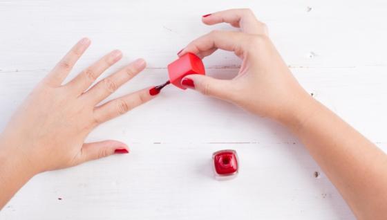 Imagen de referencia de mujer pintándose las uñas.
