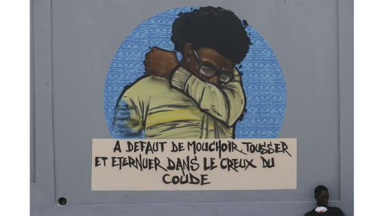 Un grupo de personas camina junto a un set de graffitis que representan los pasos higiénicos, que se deben seguir para luchar contra COVID-19 en Dakar, Senegal.  Foto: Alaattin Doğru/ Anadolu