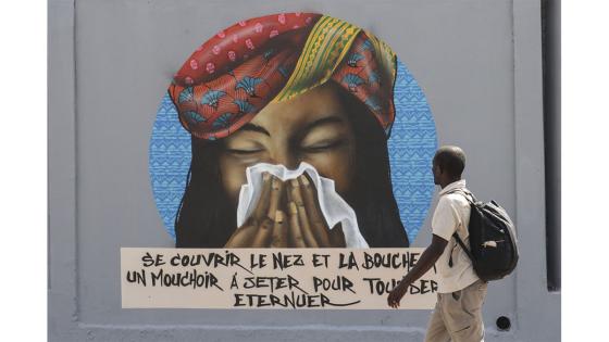 Un grupo de personas camina junto a un set de graffitis que representan los pasos higiénicos, que se deben seguir para luchar contra COVID-19 en Dakar, Senegal.  Foto: Alaattin Doğru/ Anadolu
