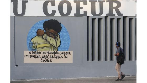 Un grupo de personas camina junto a un set de graffitis que representan los pasos higiénicos, que se deben seguir para luchar contra COVID-19 en Dakar, Senegal.  Foto: Alaattin Doğru/ Anadolu