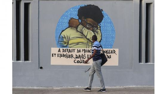 Un grupo de personas camina junto a un set de graffitis que representan los pasos higiénicos, que se deben seguir para luchar contra COVID-19 en Dakar, Senegal.  Foto: Alaattin Doğru/ Anadolu