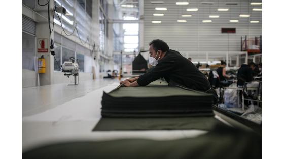 Un grupo de mujeres que forman parte de la fábrica de uniformes de la Policía Nacional pasó de fabricar uniformes a hacer tapabocas y trajes de bioseguridad.  Foto: Juancho Torres - Anadolu