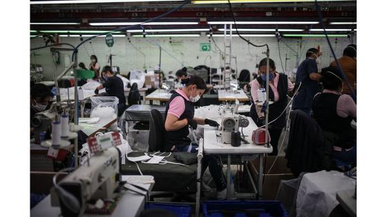 Un grupo de mujeres que forman parte de la fábrica de uniformes de la Policía Nacional pasó de fabricar uniformes a hacer tapabocas y trajes de bioseguridad.  Foto: Juancho Torres - Anadolu