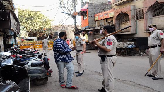 Oficiales de policía de Nueva Delhi empuñan su bastón contra personas que han roto las reglas del aislamiento nacional decretado por India dpara limitar la propagación del Coronavirus.  Foto: İmtiyaz Khan/ Anadolu