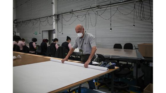Un grupo de mujeres que forman parte de la fábrica de uniformes de la Policía Nacional pasó de fabricar uniformes a hacer tapabocas y trajes de bioseguridad.  Foto: Juancho Torres - Anadolu