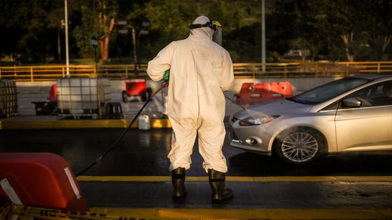 Un trabajador desinfecta los vehículos que quieren ingresar a la capital del país, durante el periodo de cuarentena impuesta para frenar la propagación de Coronavirus.  Foto: Juancho Torres/ Anadolu