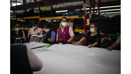 Un grupo de mujeres que forman parte de la fábrica de uniformes de la Policía Nacional pasó de fabricar uniformes a hacer tapabocas y trajes de bioseguridad.  Foto: Juancho Torres - Anadolu