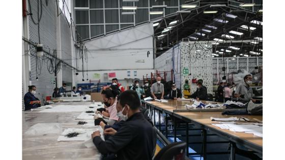 Un grupo de mujeres que forman parte de la fábrica de uniformes de la Policía Nacional pasó de fabricar uniformes a hacer tapabocas y trajes de bioseguridad.  Foto: Juancho Torres - Anadolu