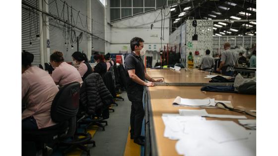 Un grupo de mujeres que forman parte de la fábrica de uniformes de la Policía Nacional pasó de fabricar uniformes a hacer tapabocas y trajes de bioseguridad.  Foto: Juancho Torres - Anadolu