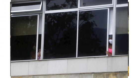 Niños observan por las ventanas durante la celebración que la Policía ofreció con motivo del Día del Niño a pacientes del Hospital Infantil San Vicente Fundación.  Foto: Luis Eduardo Noriega - EFE