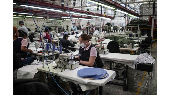 Un grupo de mujeres que forman parte de la fábrica de uniformes de la Policía Nacional pasó de fabricar uniformes a hacer tapabocas y trajes de bioseguridad.  Foto: Juancho Torres - Anadolu