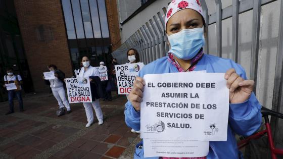 Médicos y enfermeras del Hospital de Kennedy, uno de los más grandes de Bogotá, sostienen carteles durante una protesta pidiendo al Gobierno garantías laborales y elementos de protección adecuados para enfrentar la pandemia del coronavirus en Bogotá.  Foto: Mauricio Dueñas Castañeda - EFE