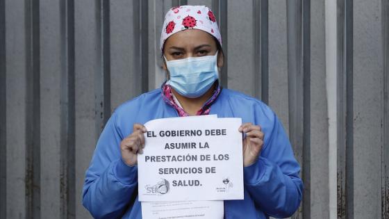 Médicos y enfermeras del Hospital de Kennedy, uno de los más grandes de Bogotá, sostienen carteles durante una protesta pidiendo al Gobierno garantías laborales y elementos de protección adecuados para enfrentar la pandemia del coronavirus en Bogotá.  Foto: Mauricio Dueñas Castañeda - EFE