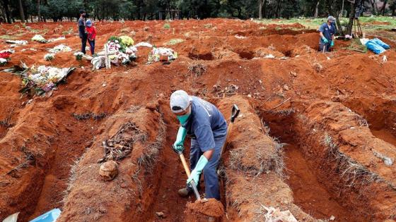 Sepultureros del cementerio de Vila Formosa, el más grande de América Latina, exhuman viejas fosas este lunes para abrir nuevos espacios a los fallecidos por COVID-19, en Sao Paulo (Brasil).