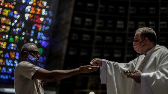Un hombre recibe la comunión en la eucaristía. 