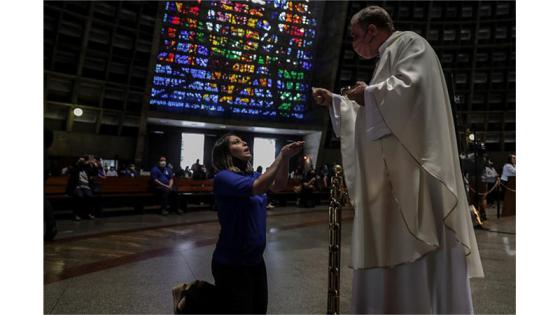 Mujer recibe la comunión en la eucaristía. 