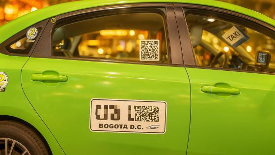 Pasajero escaneando código QR en un taxi de Bogotá