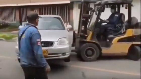 Con montacarga mueven un carro mal parqueado en Bogotá